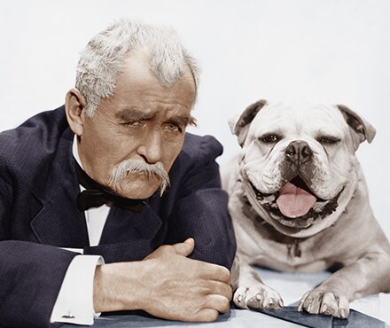 Picture of a man in a tuxedo posing with a bull dog