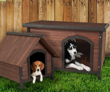 A beagle and a Husky sitting in wooden dog houses