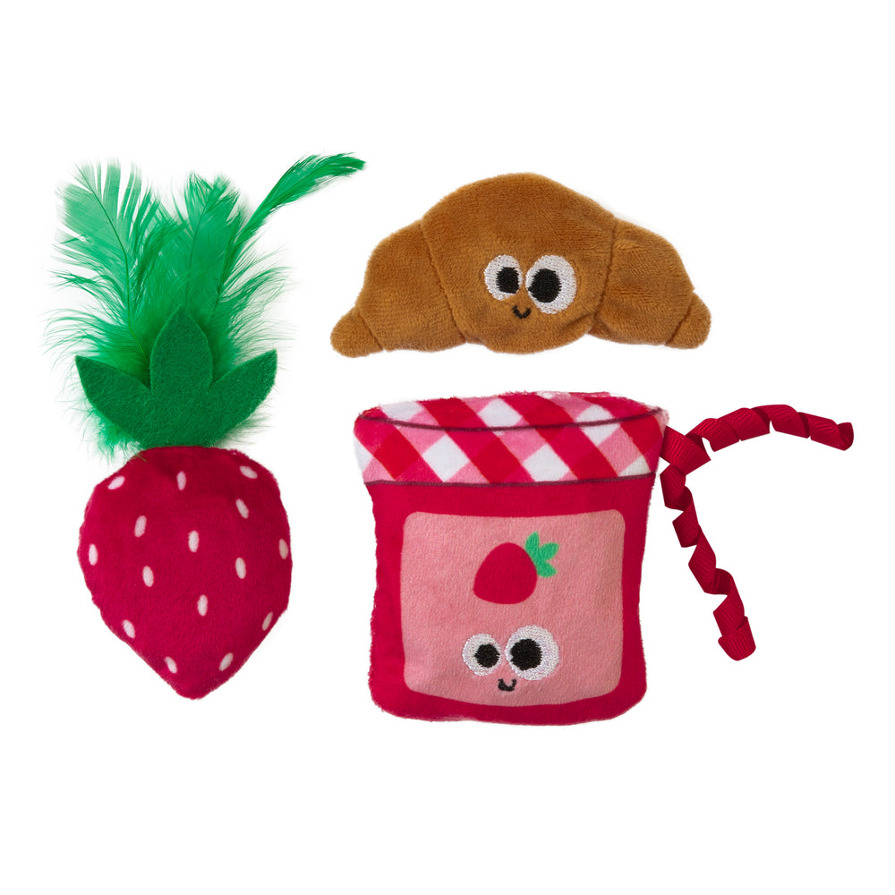 The Mad Cat Kitty Croissant 3 Pack™ by Mad Cat includes three plush toys: a strawberry with green feathers, a smiling croissant, and a pink jam jar with strawberry prints. Each vibrant, catnip-infused toy features playful expressions to entertain your feline friend.