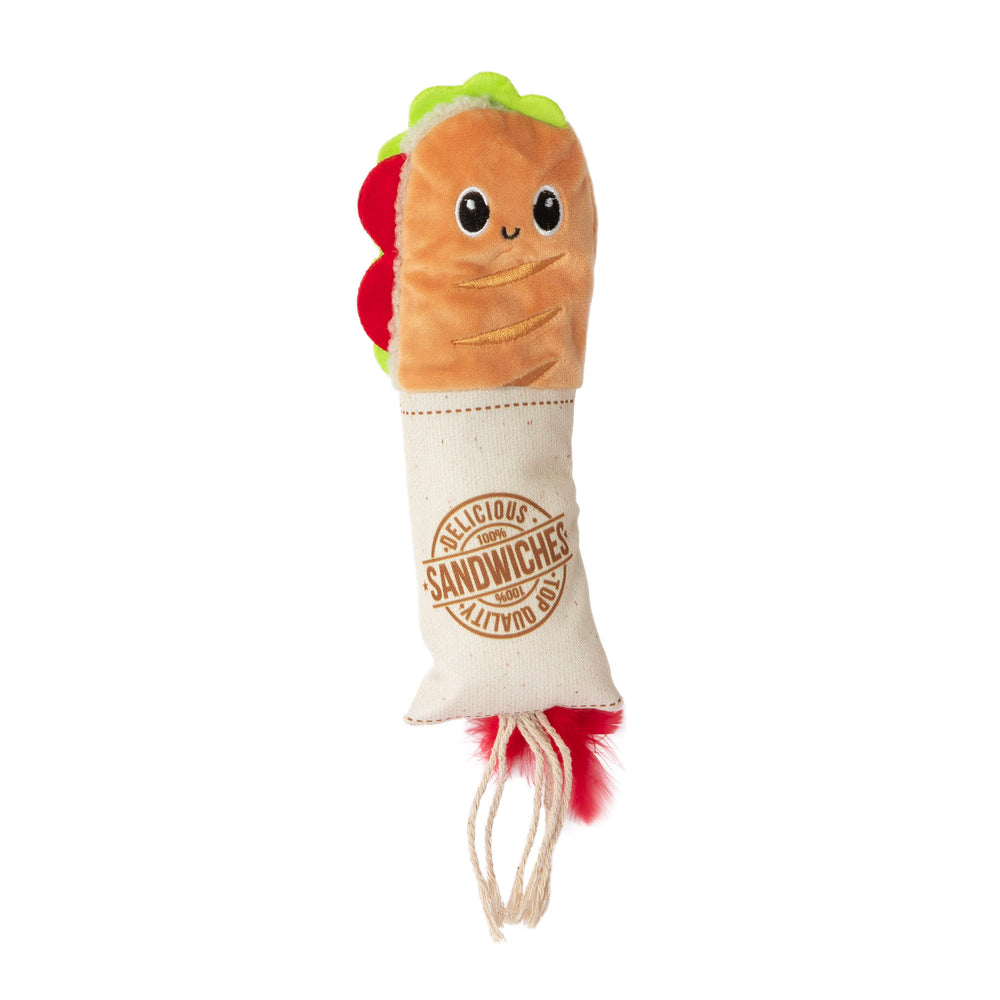 The Quirky Kitty Deli Delight Kicker, shaped like a sandwich, is a perfect cat toy. It has friendly eyes, a smile on top, colorful lettuce and tomato fabric, catnip infusion, a canvas-like bottom with Delicious Sandwiches lettering, and a red natural feather tail.